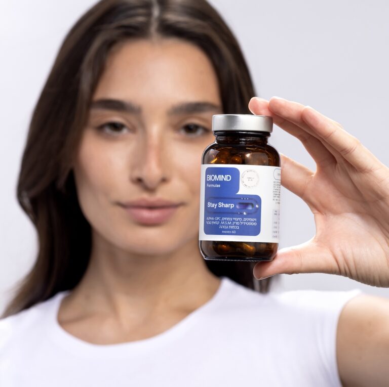 אישה מחזיקה את STAY SHARP - תוסף טבעי מבית ביומיינד לתמיכה בריכוז בלימודים
