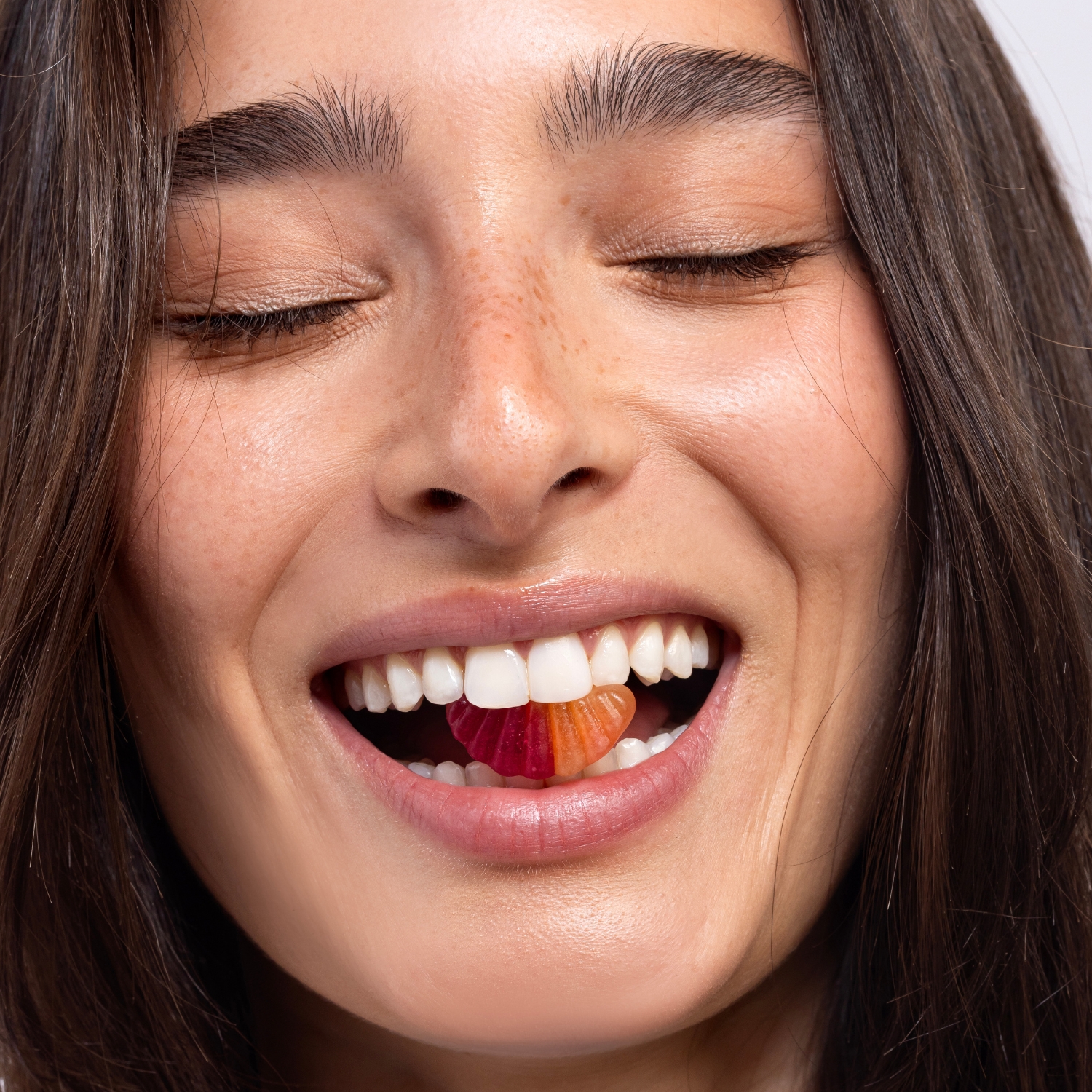 אישה מחייכת עם פרוביוטיקה בגומי לעיכול ונפיחות - GumBiotic | גאמביוטיק